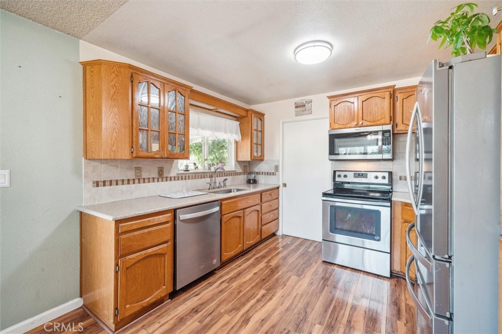 6791 Whispering Canyon Drive Anderson, CA 96007 - Photo 10 of 51 a kitchen with stainless steel appliances granite countertop a stove a sink dishwasher and a refrigerator