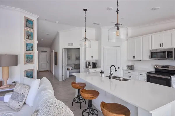 a kitchen with stainless steel appliances living room dining table and chairs