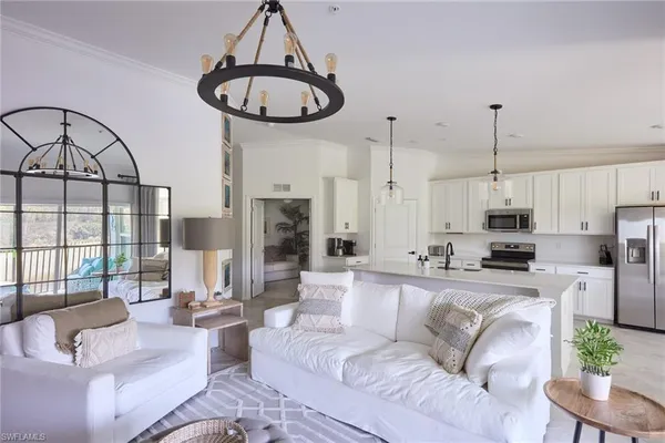 a living room with furniture a fireplace and a chandelier