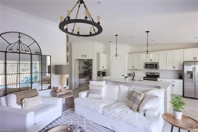 a living room with furniture a fireplace and a chandelier