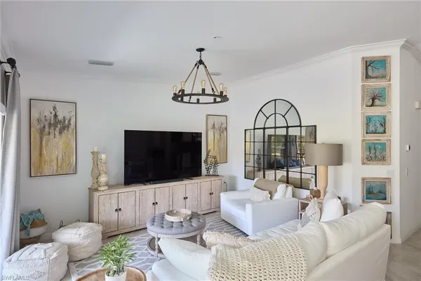 a living room with furniture a flat screen tv and a view of kitchen