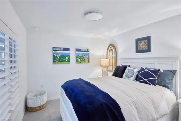 a bedroom with a bed and a painting on the wall