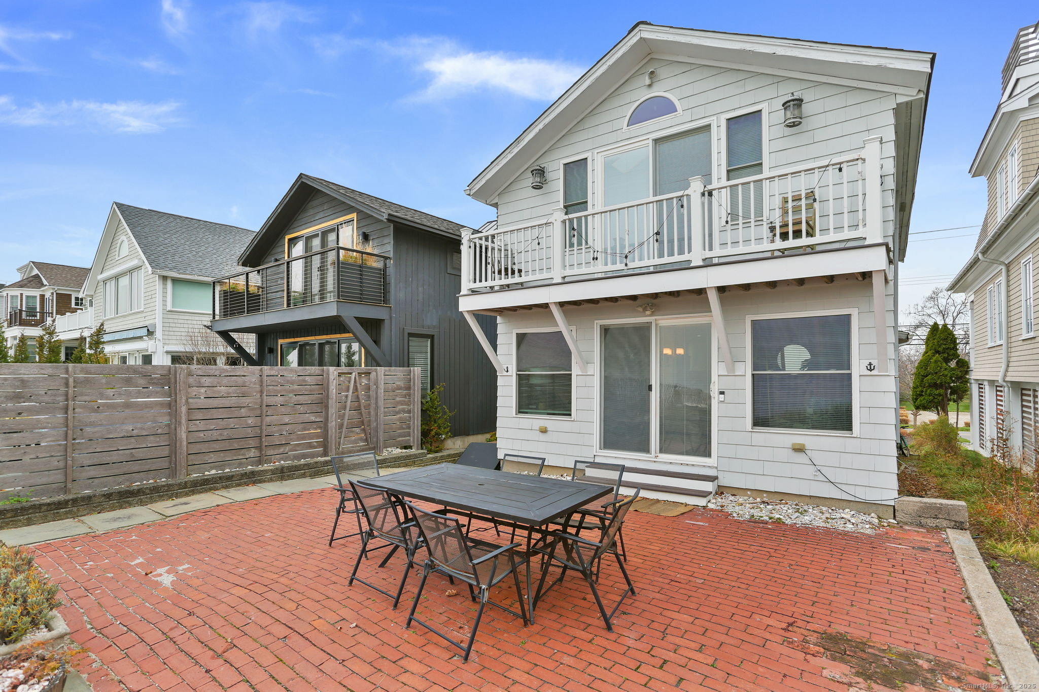 1235-1236 Fairfield Beach Road Fairfield, CT 06824 - Photo 23 of 39 a front view of a house with a yard table and chairs