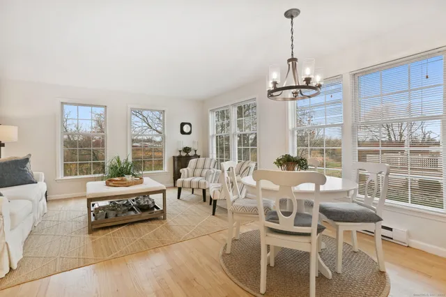 a living room with furniture a chandelier and a dining table