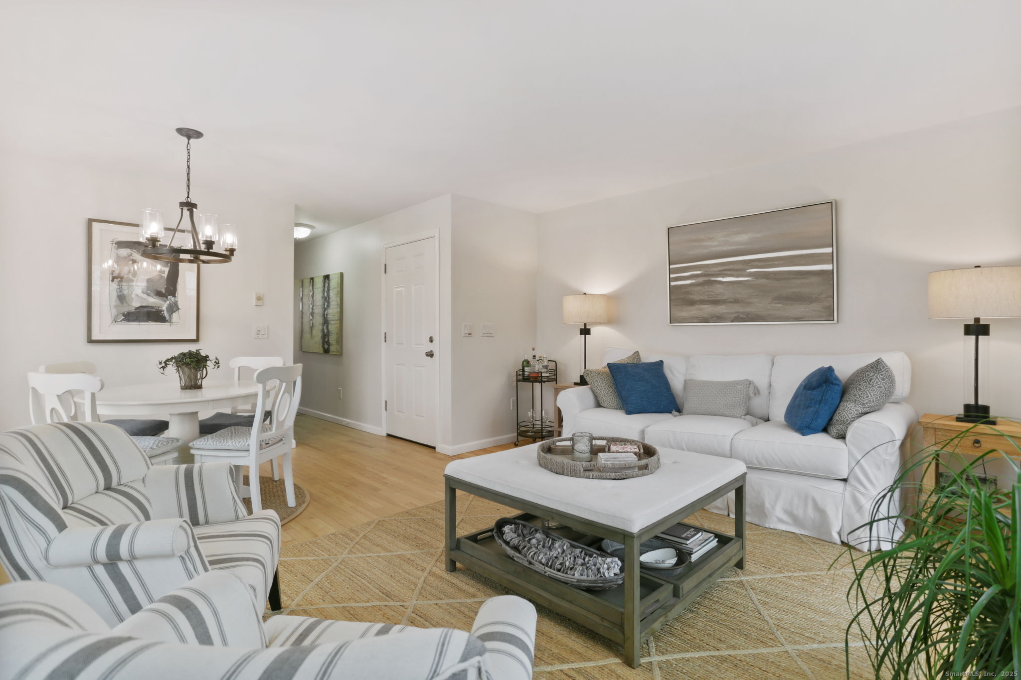 1235 Fairfield Beach Road Fairfield, CT 06824 - Photo 31 of 39 a living room with furniture a chandelier and a dining table