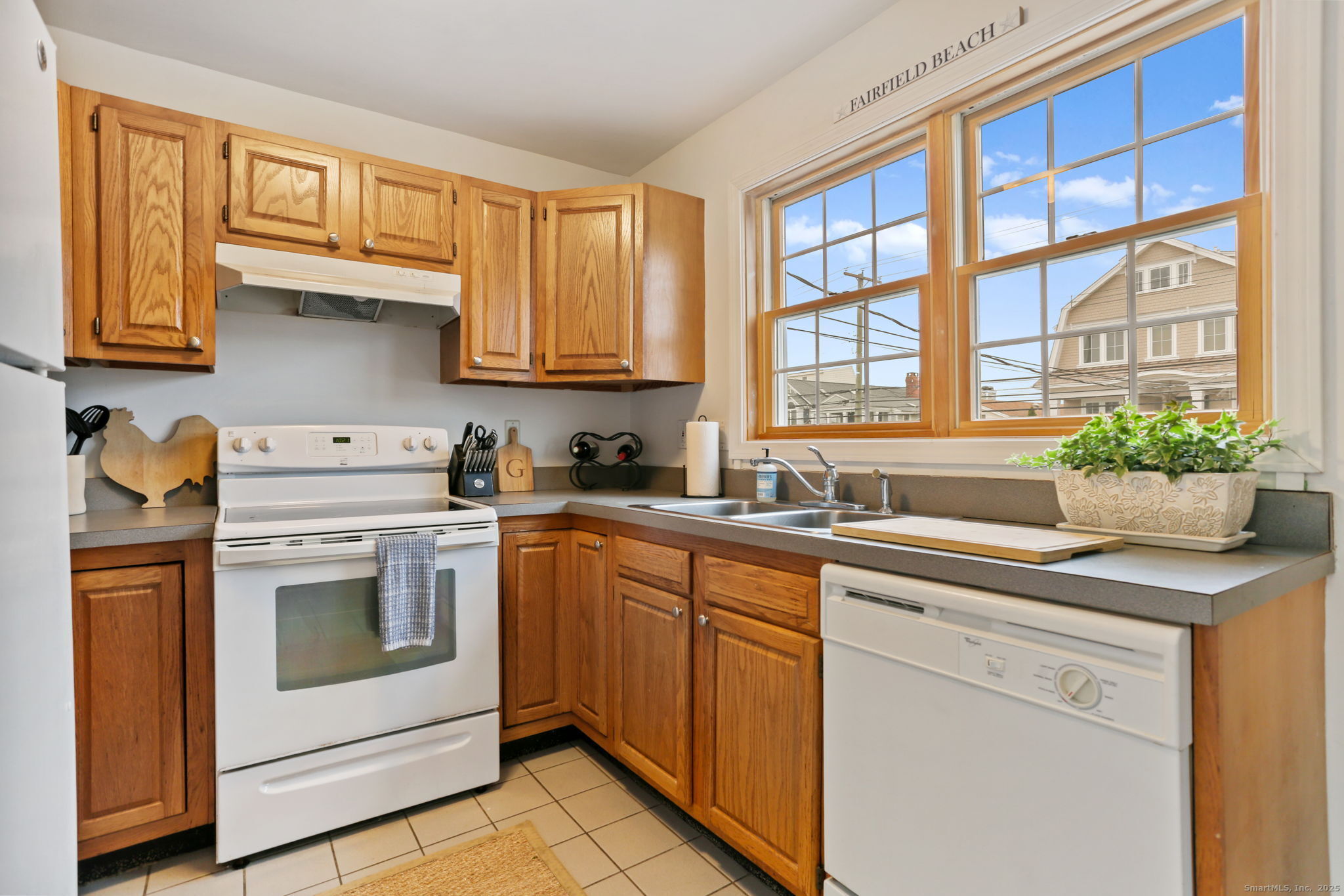 1235 Fairfield Beach Road Fairfield, CT 06824 - Photo 32 of 39 a kitchen with stainless steel appliances granite countertop a sink and cabinets