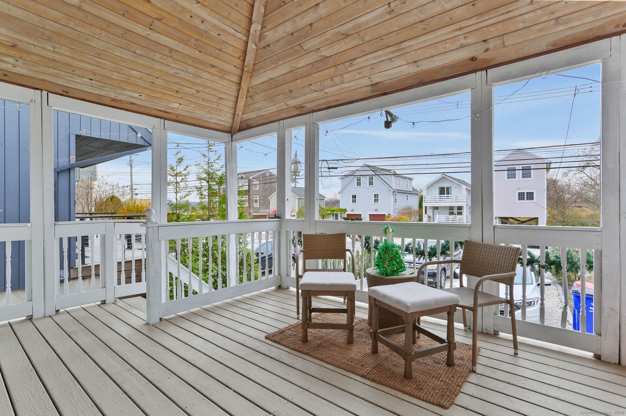 1235-1236 Fairfield Beach Road Fairfield, CT 06824 - Photo 6 of 39 a balcony with furniture and wooden floor