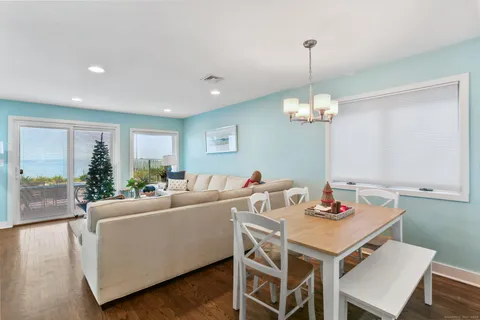 a view of a dining room and livingroom with furniture wooden floor a chandelier