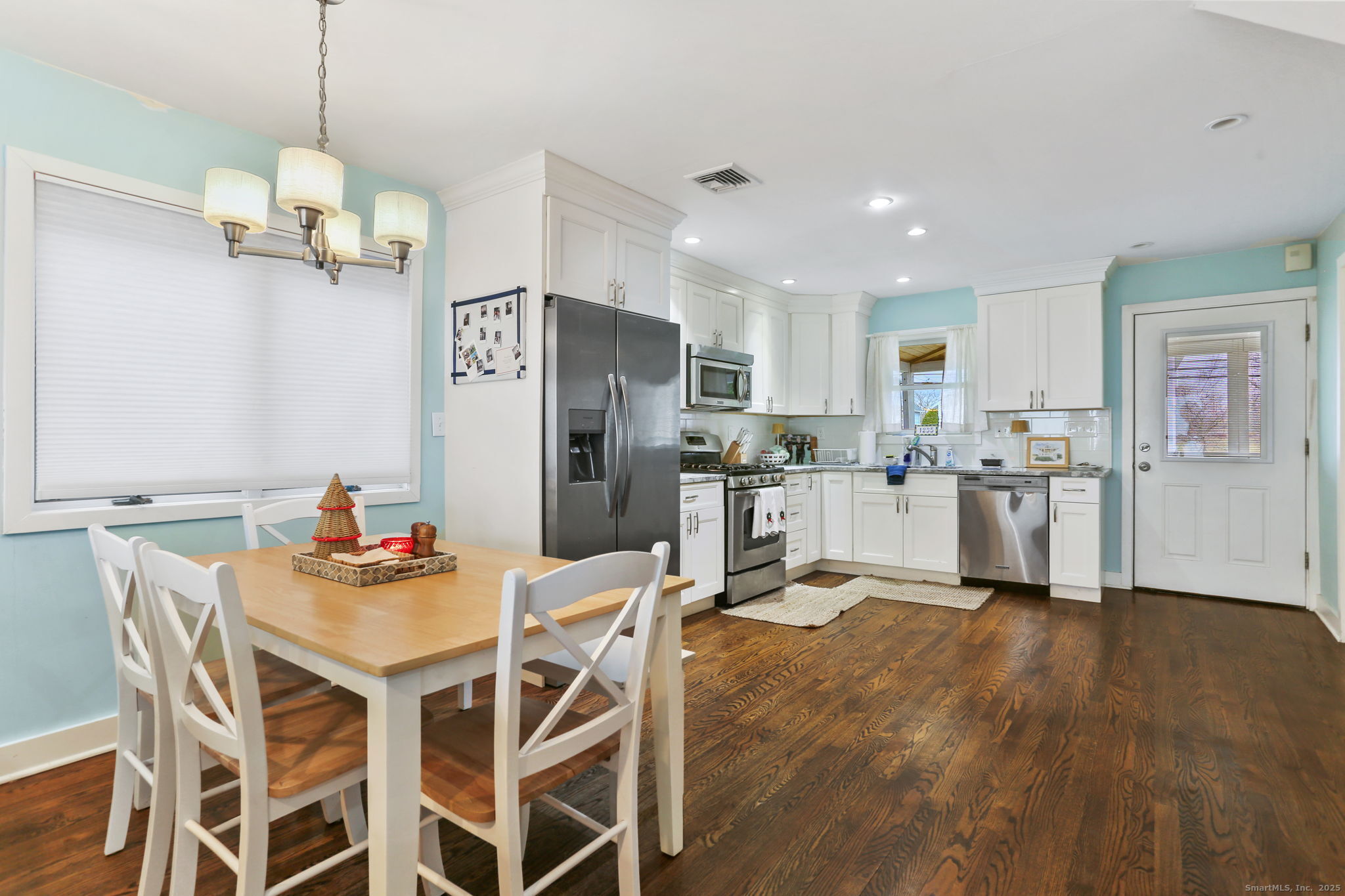 1235 Fairfield Beach Road Fairfield, CT 06824 - Photo 8 of 39 a view of a dining room and livingroom with furniture wooden floor a chandelier