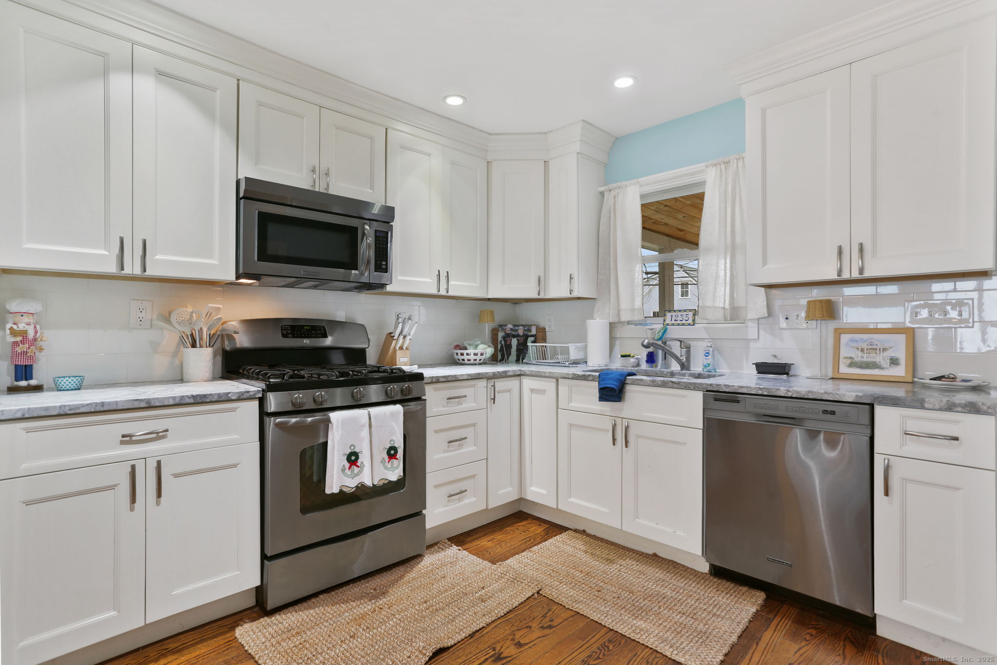 1235-1236 Fairfield Beach Road Fairfield, CT 06824 - Photo 8 of 39 a kitchen with cabinets stainless steel appliances and a sink
