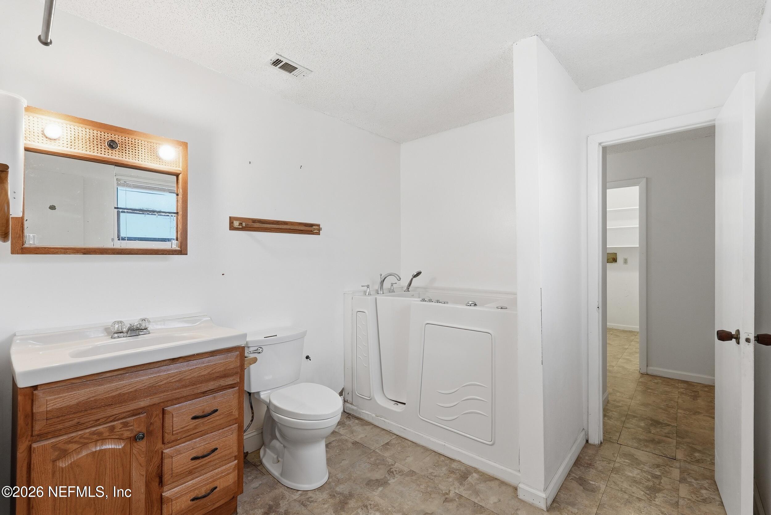 7593 Silver Sands Road Keystone Heights, FL 32656 - Photo 22 of 36 a bathroom with a toilet sink and mirror