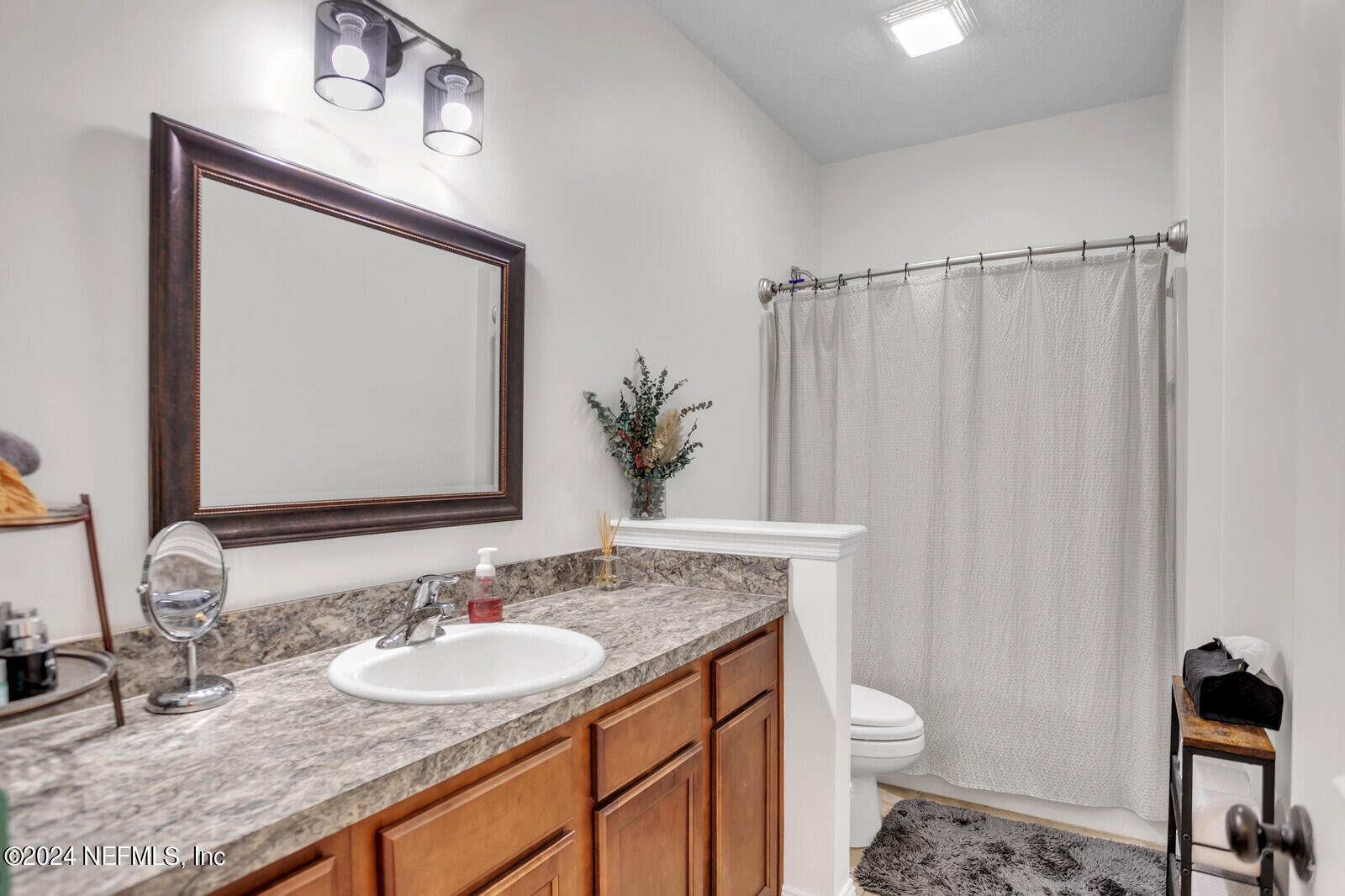4190 Quiet Crk Loop Middleburg, FL 32068 - Photo 17 of 22 a bathroom with a granite countertop sink a toilet and a mirror