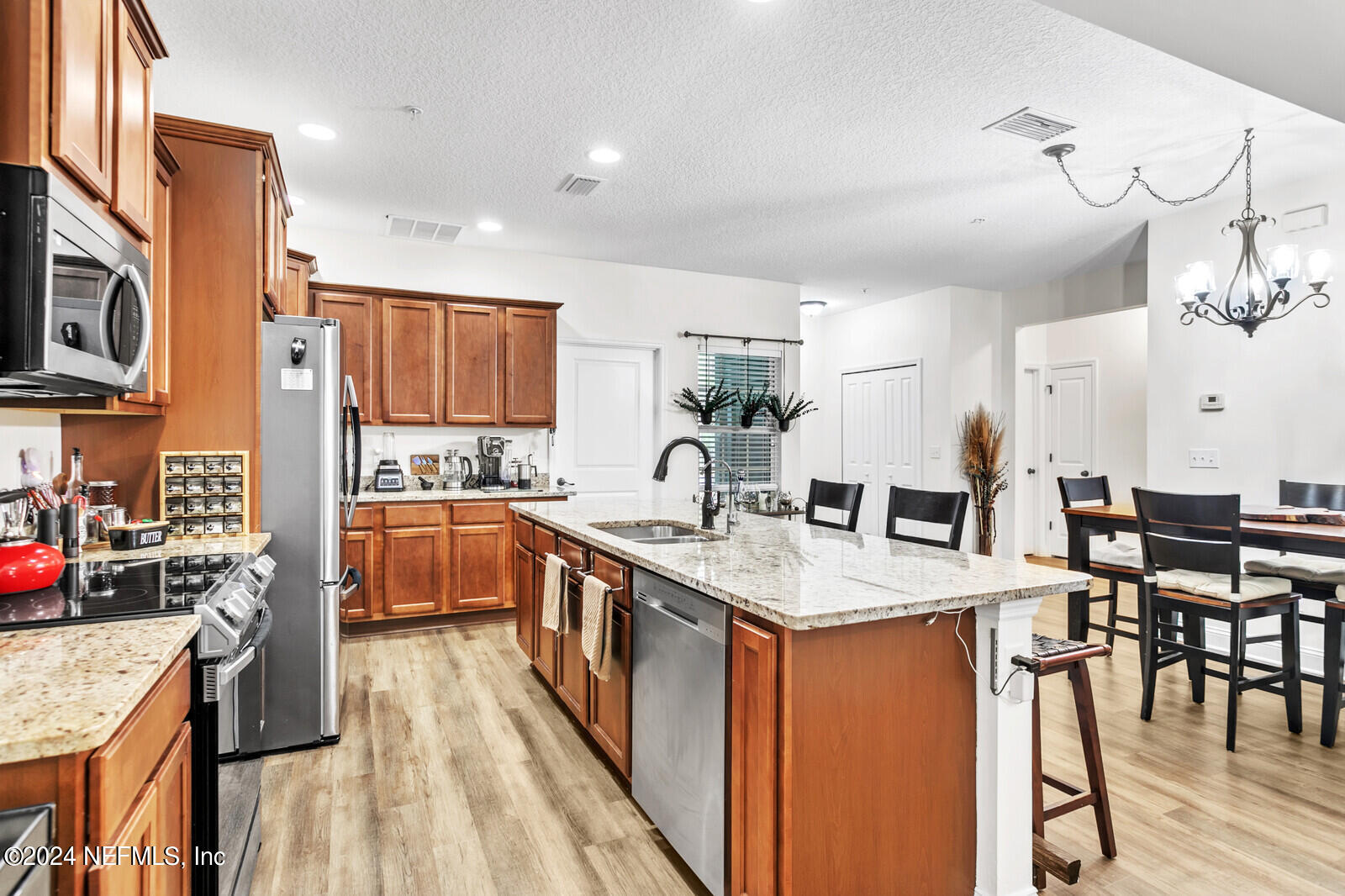 4190 Quiet Crk Loop Middleburg, FL 32068 - Photo 8 of 22 a open kitchen with stainless steel appliances granite countertop a stove top oven a sink dishwasher and white cabinets with wooden floor