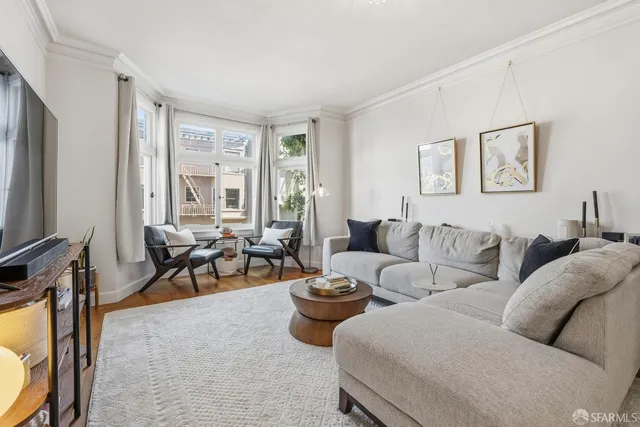 a living room with furniture a large window and a flat screen tv
