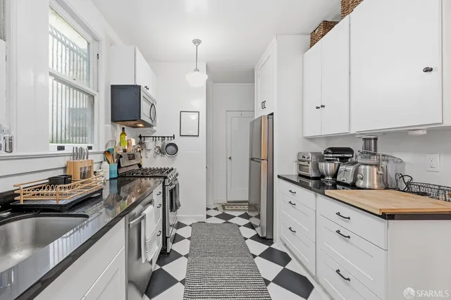 a kitchen with stainless steel appliances a sink stove and refrigerator