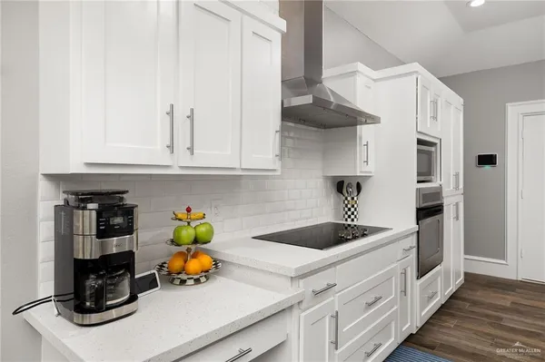 a kitchen with stainless steel appliances granite countertop a sink dishwasher stove and cabinets with wooden floor