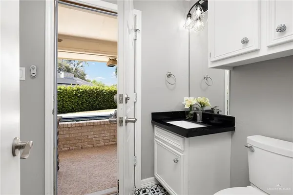 a bathroom with a granite countertop sink and a toilet
