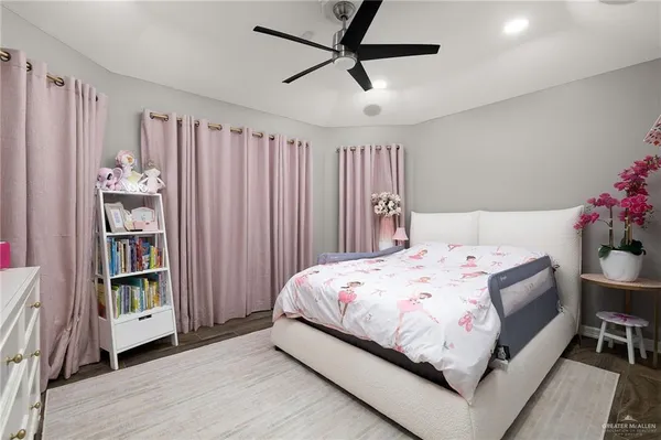 a bedroom with a bed bookshelf and a window