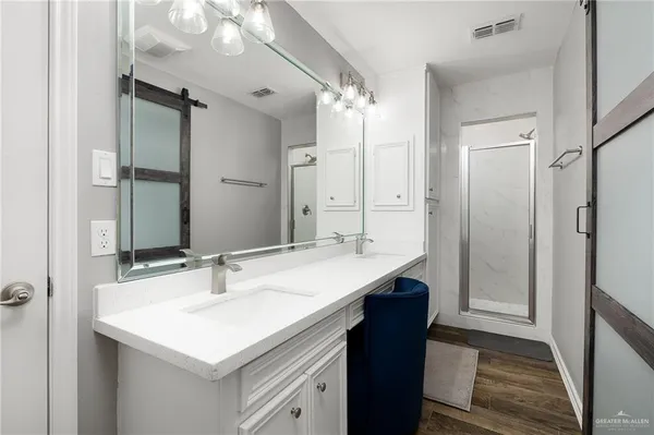 a bathroom with a sink a mirror a vanity and a shower
