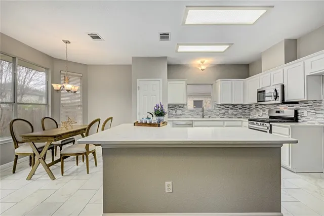 a kitchen with kitchen island a sink table and chairs