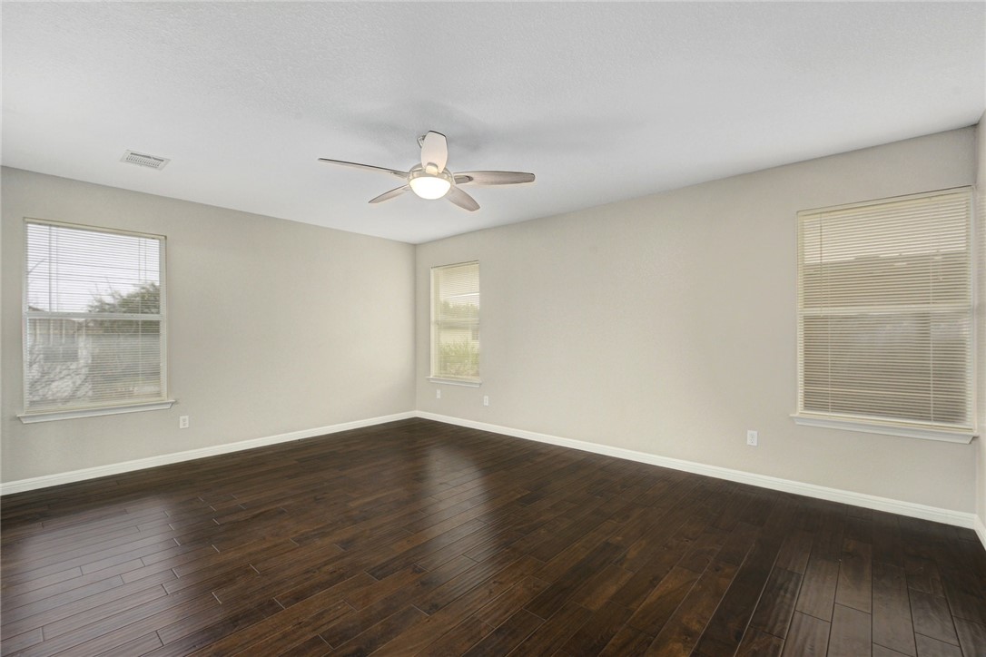3504 Texas Topaz Drive Austin, TX 78728 - Photo 16 of 29 a view of an empty room with wooden floor and a window