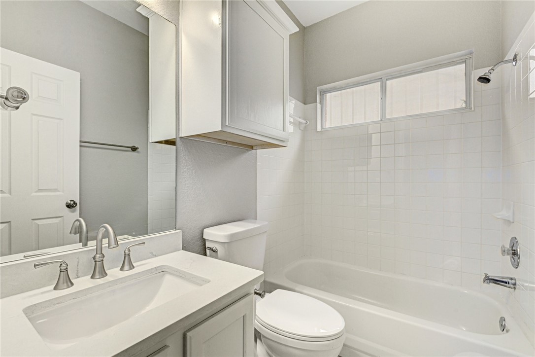 3504 Texas Topaz Drive Austin, TX 78728 - Photo 24 of 29 a bathroom with a bathtub shower sink vanity mirror and toilet
