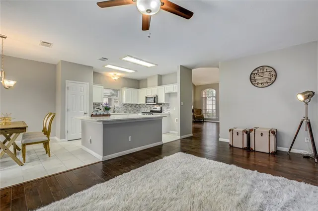 a large white kitchen with wooden floor