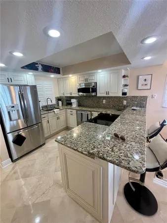 a kitchen with stainless steel appliances granite countertop a sink stove and cabinets