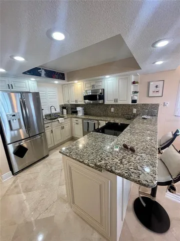 a kitchen with stainless steel appliances granite countertop a sink stove and cabinets