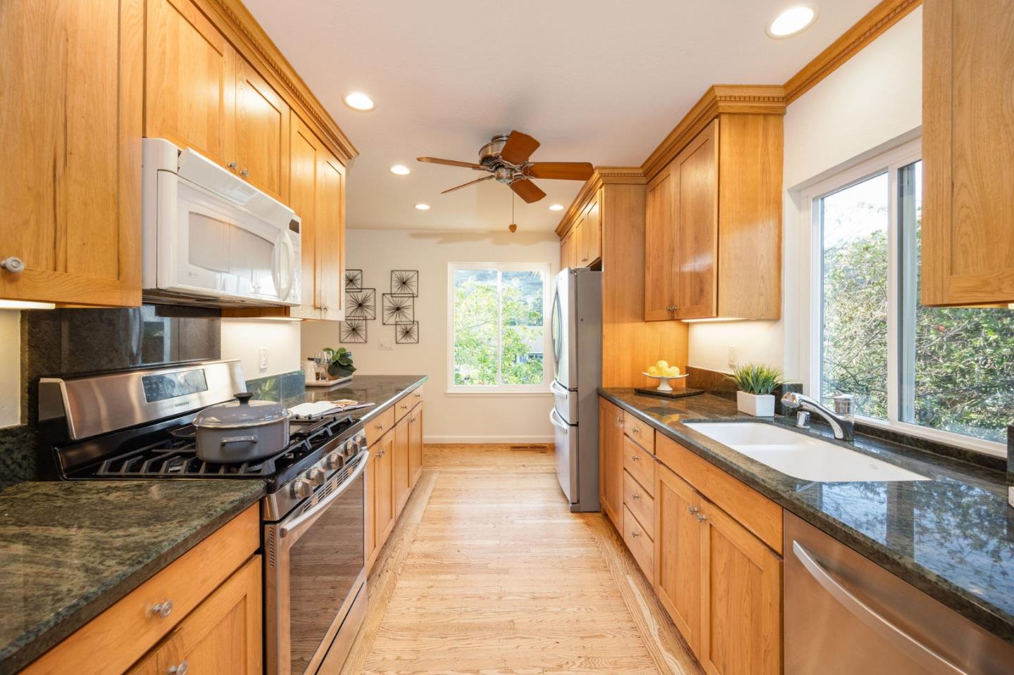 1204 Rainier Avenue Pacifica, CA 94044 - Photo 8 of 38 a kitchen with stainless steel appliances granite countertop a sink a stove and a wooden cabinets