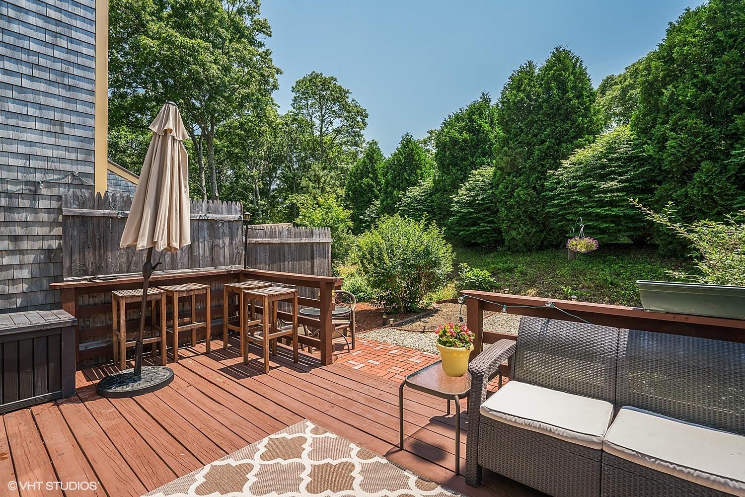 67 Round House Road Bourne, MA 02532 - Photo 13 of 15 a view of a patio with couches table and chairs and potted plants with wooden floor and fence