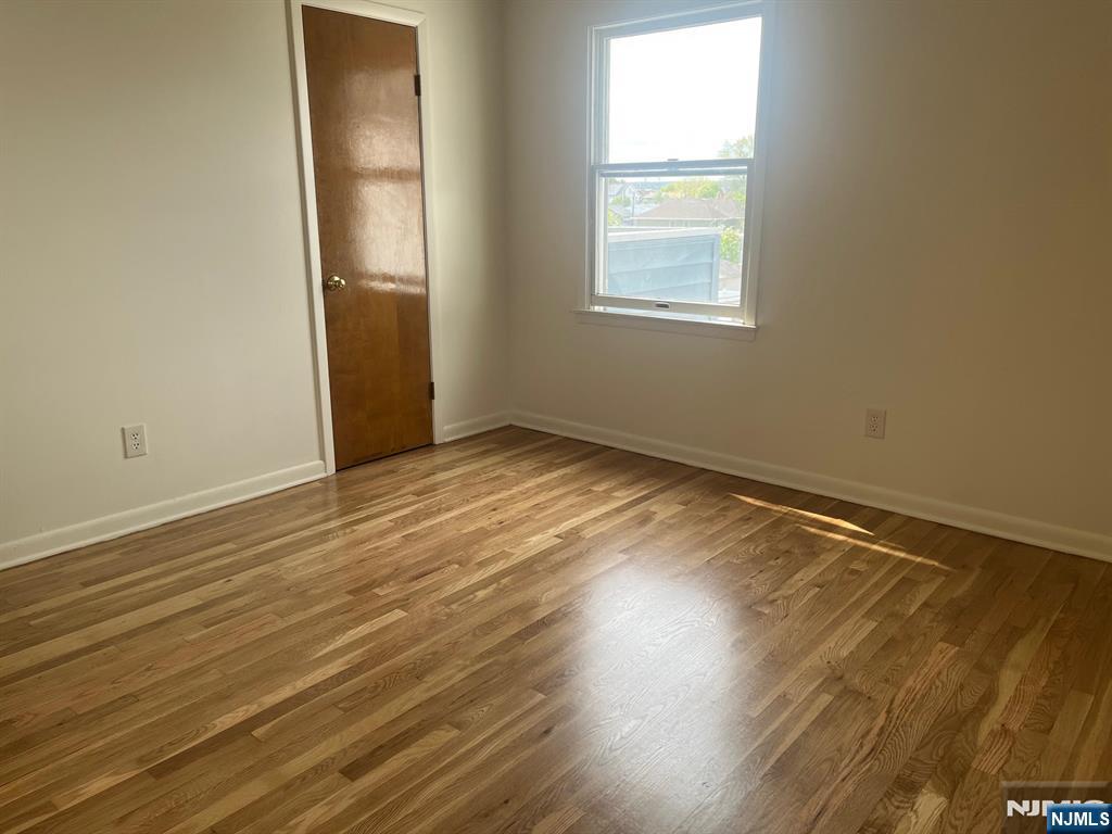 635 B Ridge Road, Unit B Lyndhurst, NJ 07071 - Photo 8 of 16 an empty room with wooden floor and windows