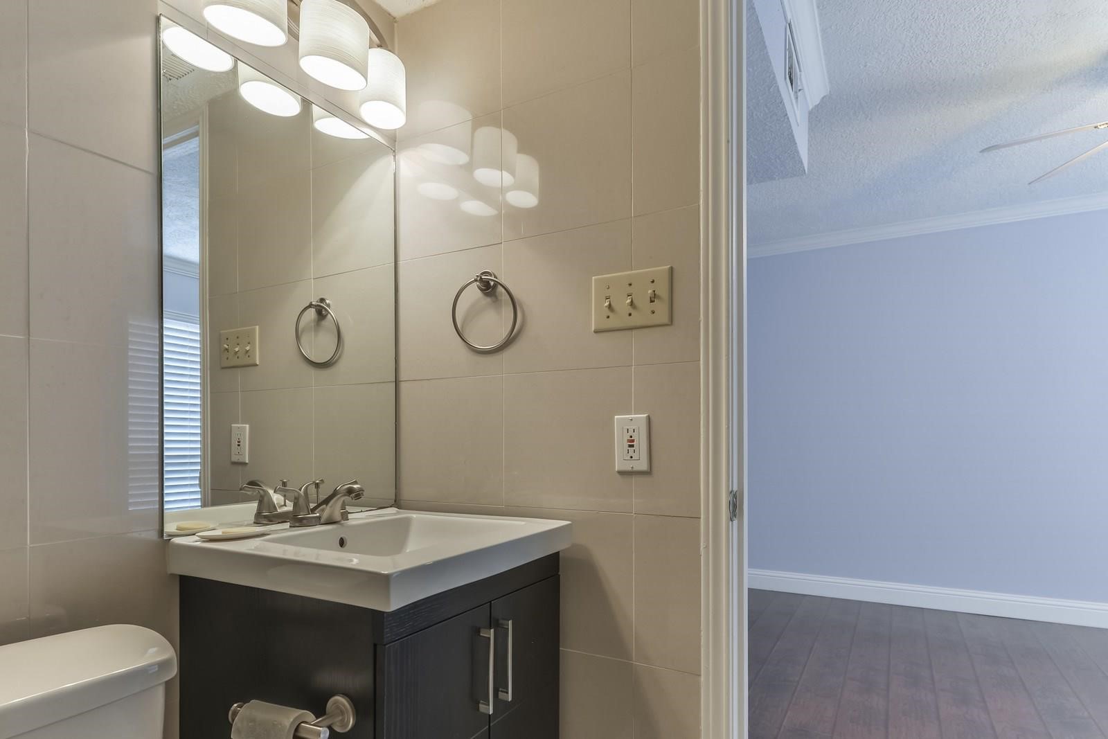 6402 Del Monte Drive, Unit 45 Houston, TX 77057 - Photo 14 of 20 a bathroom with a sink a toilet and mirror