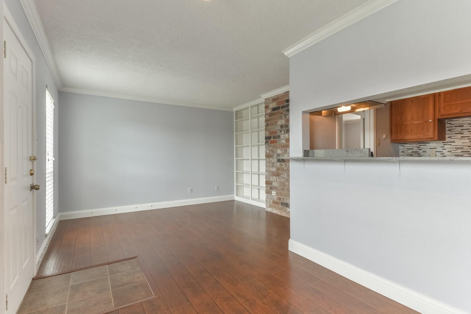 6402 Del Monte Drive, Unit 45 Houston, TX 77057 - Photo 5 of 20 an empty room with wooden floor and a window