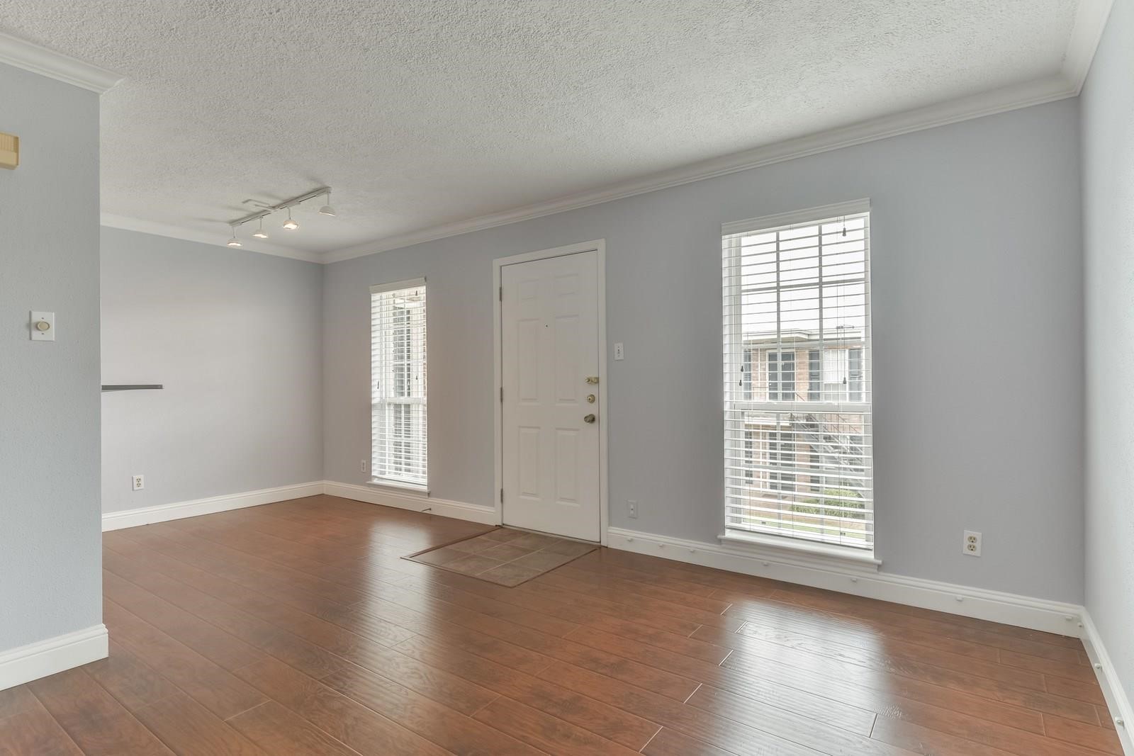 6402 Del Monte Drive, Unit 45 Houston, TX 77057 - Photo 6 of 20 an empty room with wooden floor and windows