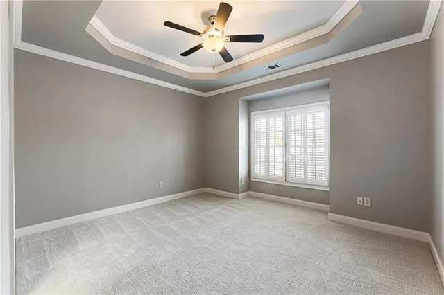 an empty room with window and ceiling fan