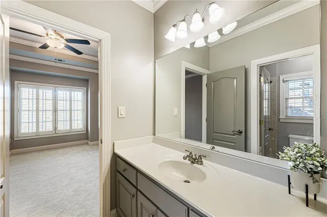 a bathroom with a granite countertop sink toilet a mirror and shower
