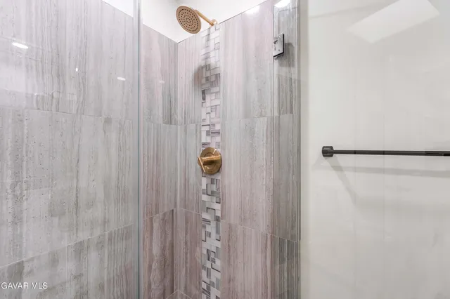 a spacious bedroom with a bed a couch and a potted plant on the dresser