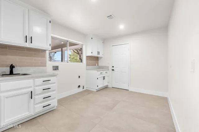 a bathroom with a granite countertop double vanity sink and mirror