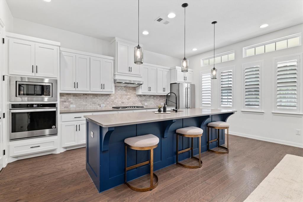 1561 William Way Dallas, TX 75234 - Photo 5 of 38 a kitchen with granite countertop a table chairs stove a sink dishwasher and cabinets with wooden floor