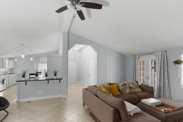 a living room with furniture and kitchen view