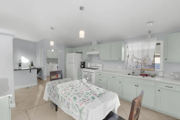 a open kitchen with kitchen island a sink stove and white cabinets
