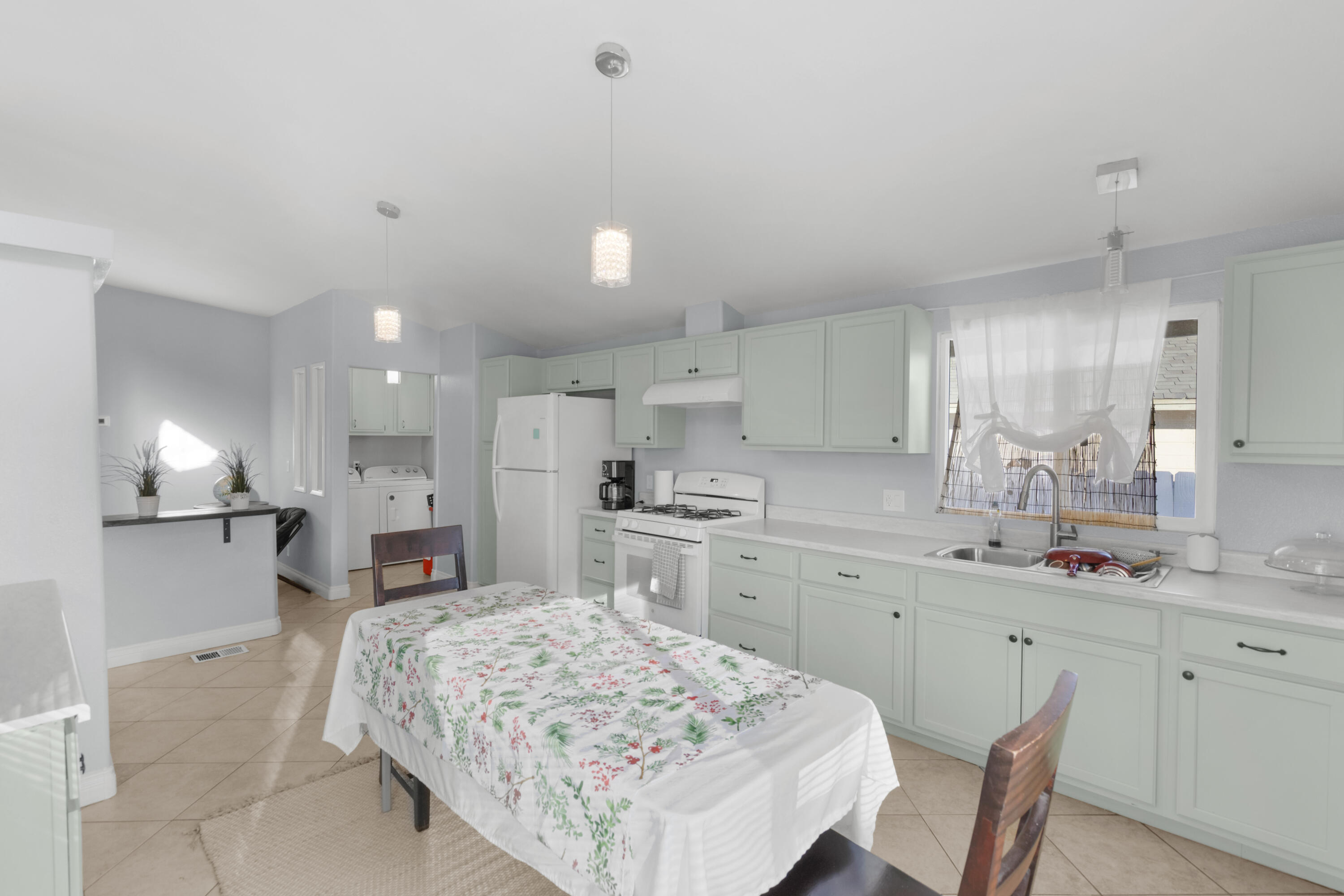 47800 Madison Street, Unit 44 Indio, CA 92201 - Photo 21 of 25 a open kitchen with kitchen island a sink stove and white cabinets