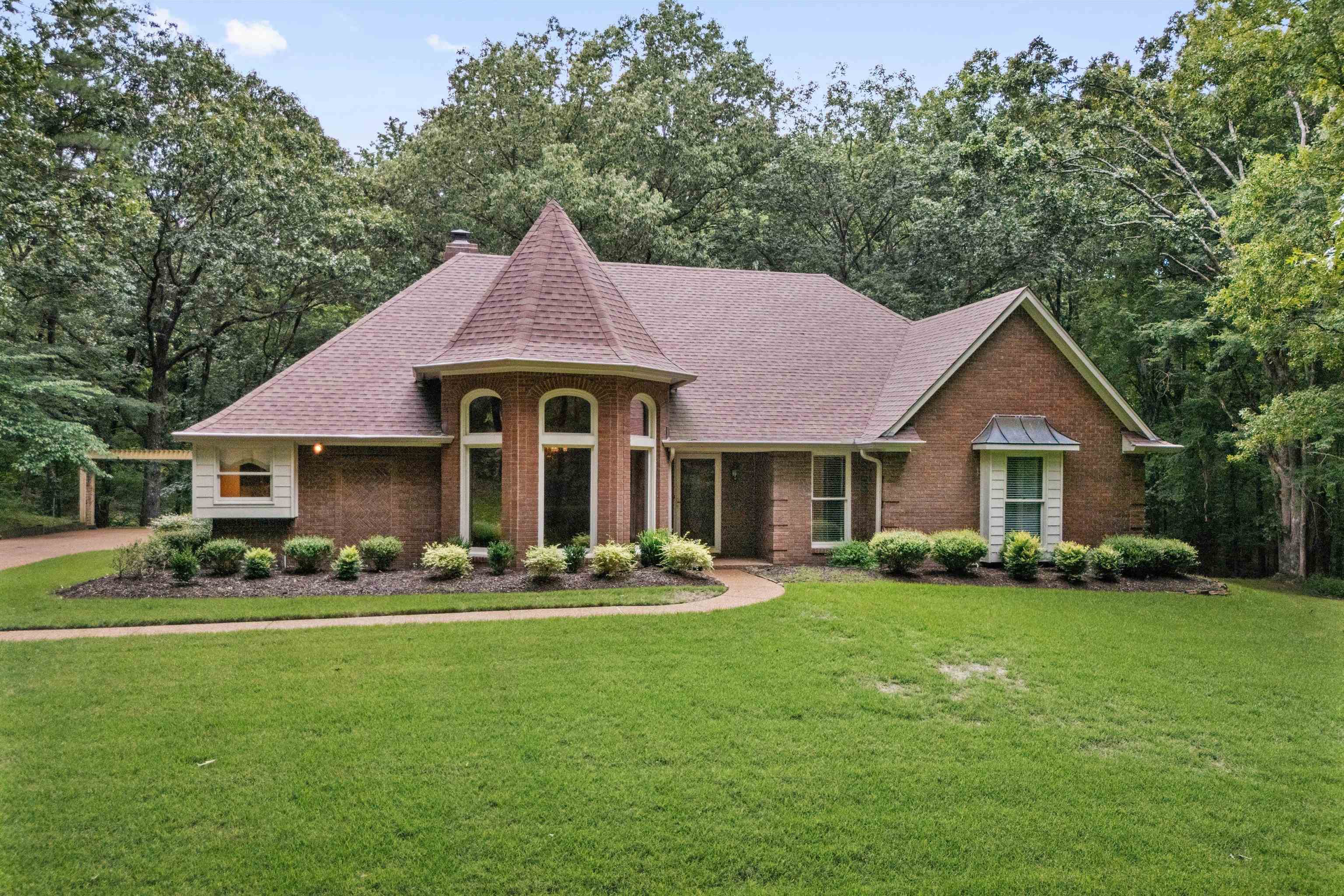 View of front of home with roof with shingles, a chimney, a front lawn, and brick siding