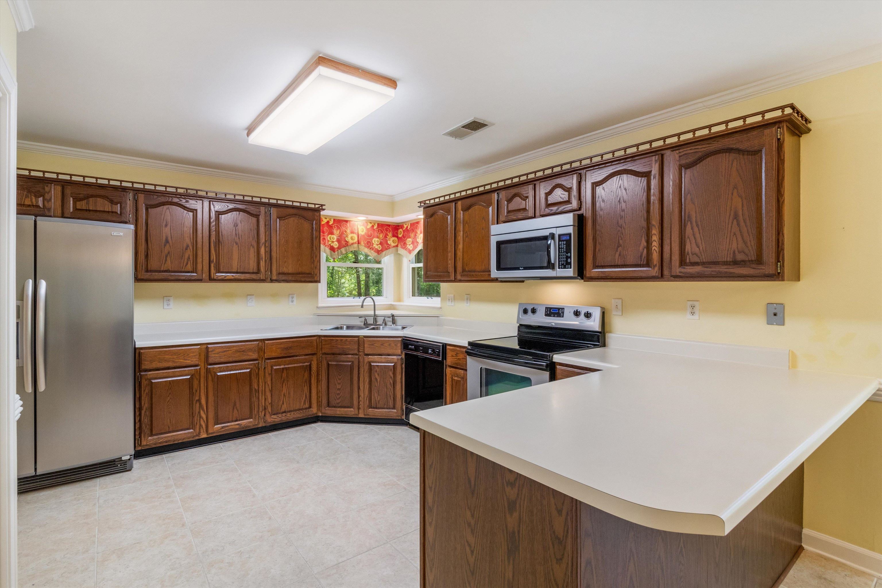 4081 Brunswick Road Bartlett, TN 38133 - Photo 11 of 31 Kitchen featuring stainless steel appliances, a peninsula, light countertops, and ornamental molding