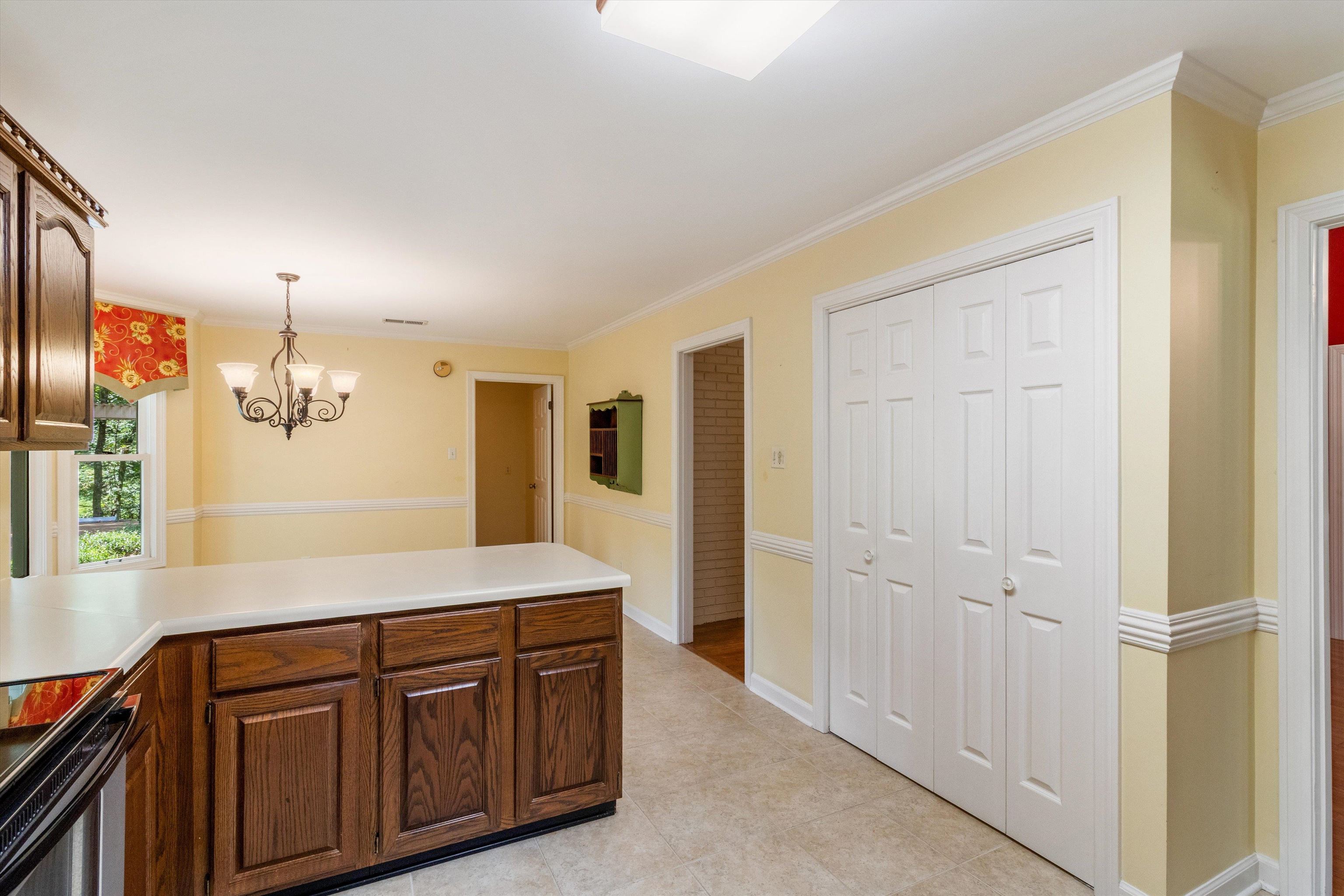 4081 Brunswick Road Bartlett, TN 38133 - Photo 13 of 31 Kitchen featuring a peninsula, crown molding, electric range, light countertops, and a chandelier