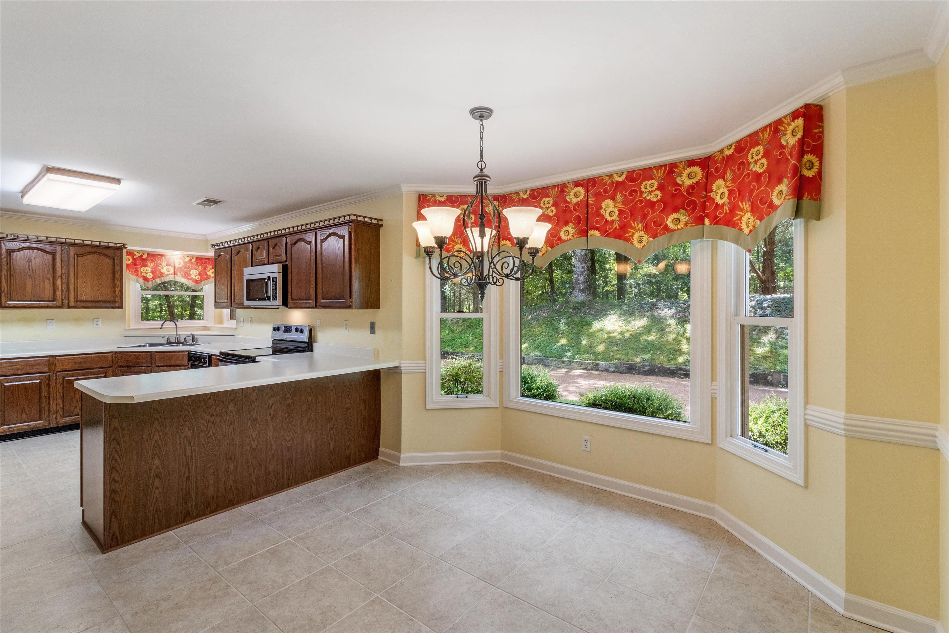 4081 Brunswick Road Bartlett, TN 38133 - Photo 14 of 31 Kitchen with appliances with stainless steel finishes, light countertops, a peninsula, a chandelier, and light tile patterned floors