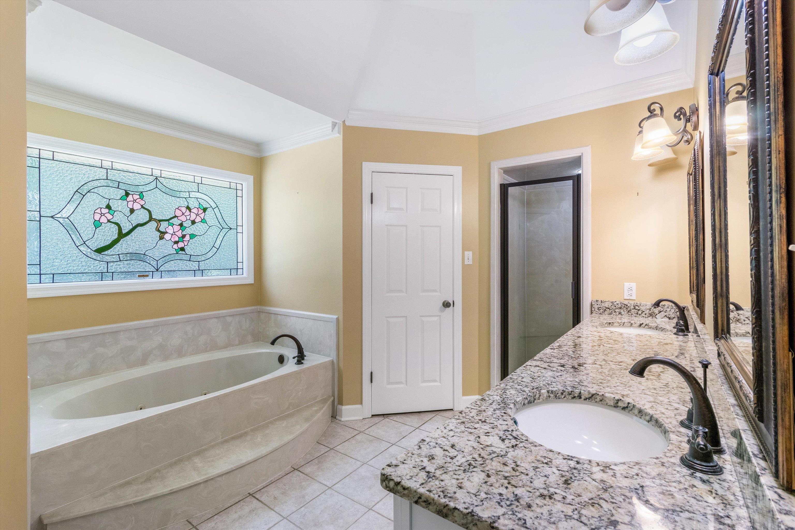 4081 Brunswick Road Bartlett, TN 38133 - Photo 18 of 31 Bathroom featuring double vanity, a whirlpool tub, tile patterned floors, ornamental molding, and a shower stall
