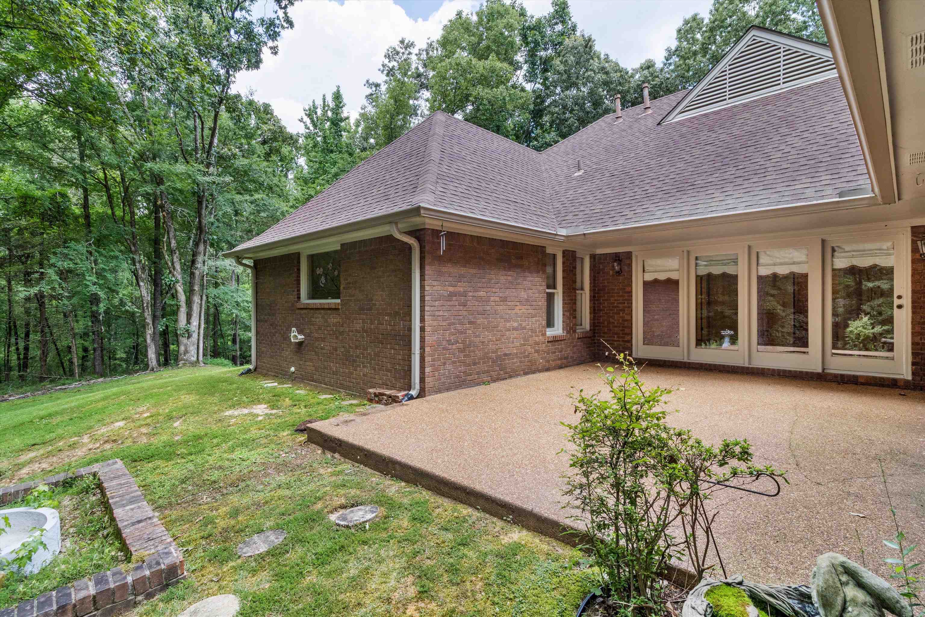 4081 Brunswick Road Bartlett, TN 38133 - Photo 26 of 31 Back of property featuring a patio area, roof with shingles, brick siding, and a lawn