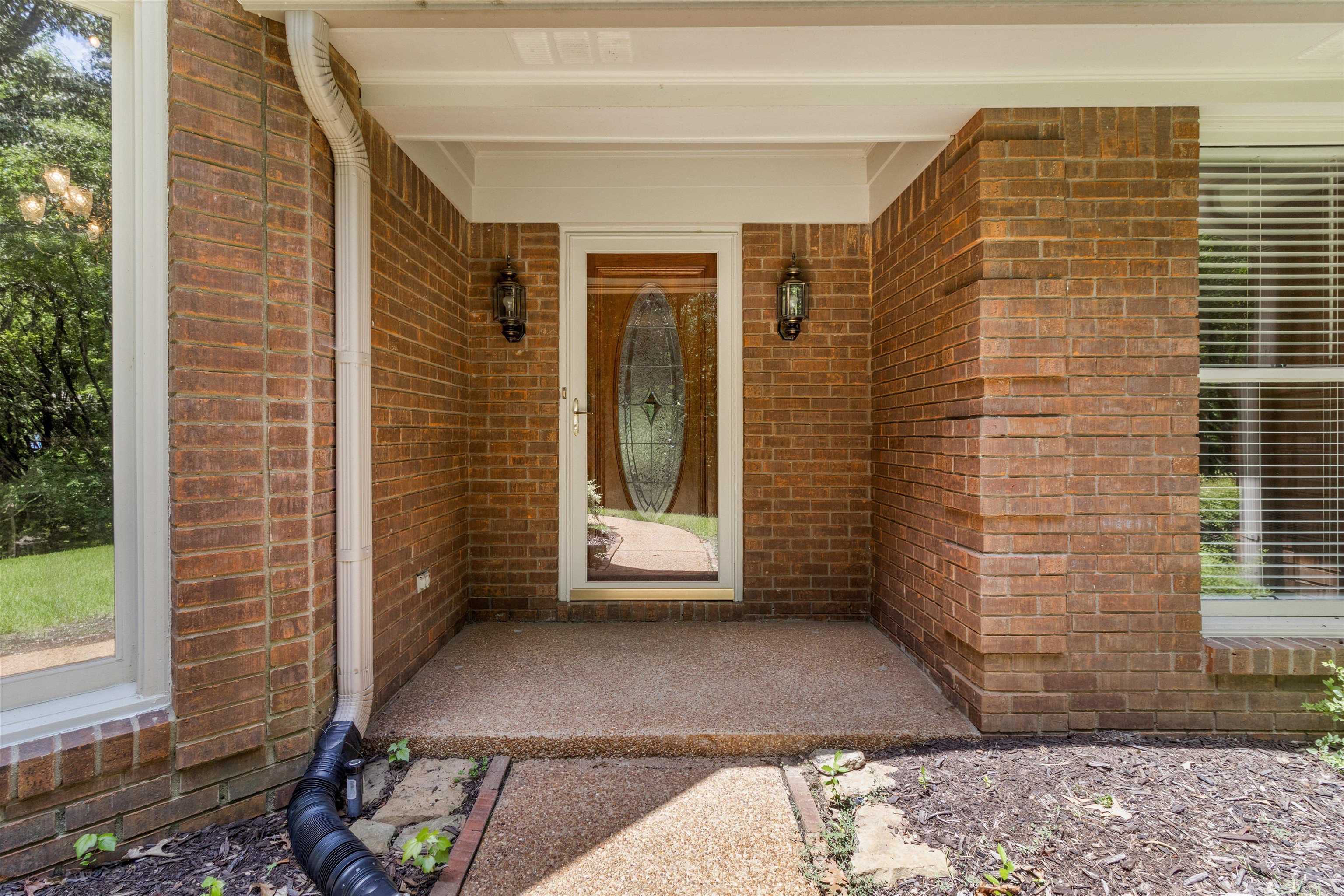 Doorway to property featuring brick siding